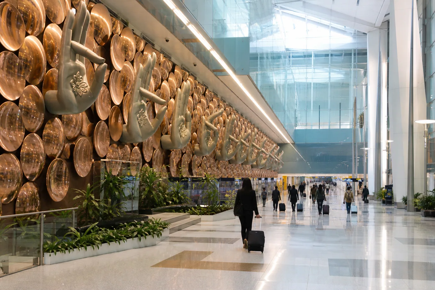 Modern Delhi airport interior with bronze hand sculptures